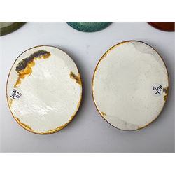 Henry George Murphy (1884-1939), collection of seven Arts & Crafts glazed ceramic roundels, of circular and oval form, five in tones of red and brown and two in tones of blue, turquoise and green in soufflé and high fired finishes, largest example D6.5cm