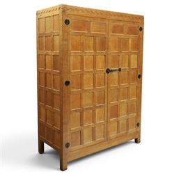 Mouseman - early-to-mid-20th century panelled and adzed double wardrobe, the arcade carved cresting rail over two panelled doors, with wrought metal hinges and latch, deep relief carved mouse signature, the interior fitted with hanging rail, by the workshop of Robert Thompson of Kilburn