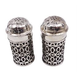 Pair of Edwardian silver salt shakers, each of cylindrical form, with pierced decoration, hallmarked Walker & Hall, Sheffield 1901, H7cm, with blue glass liners