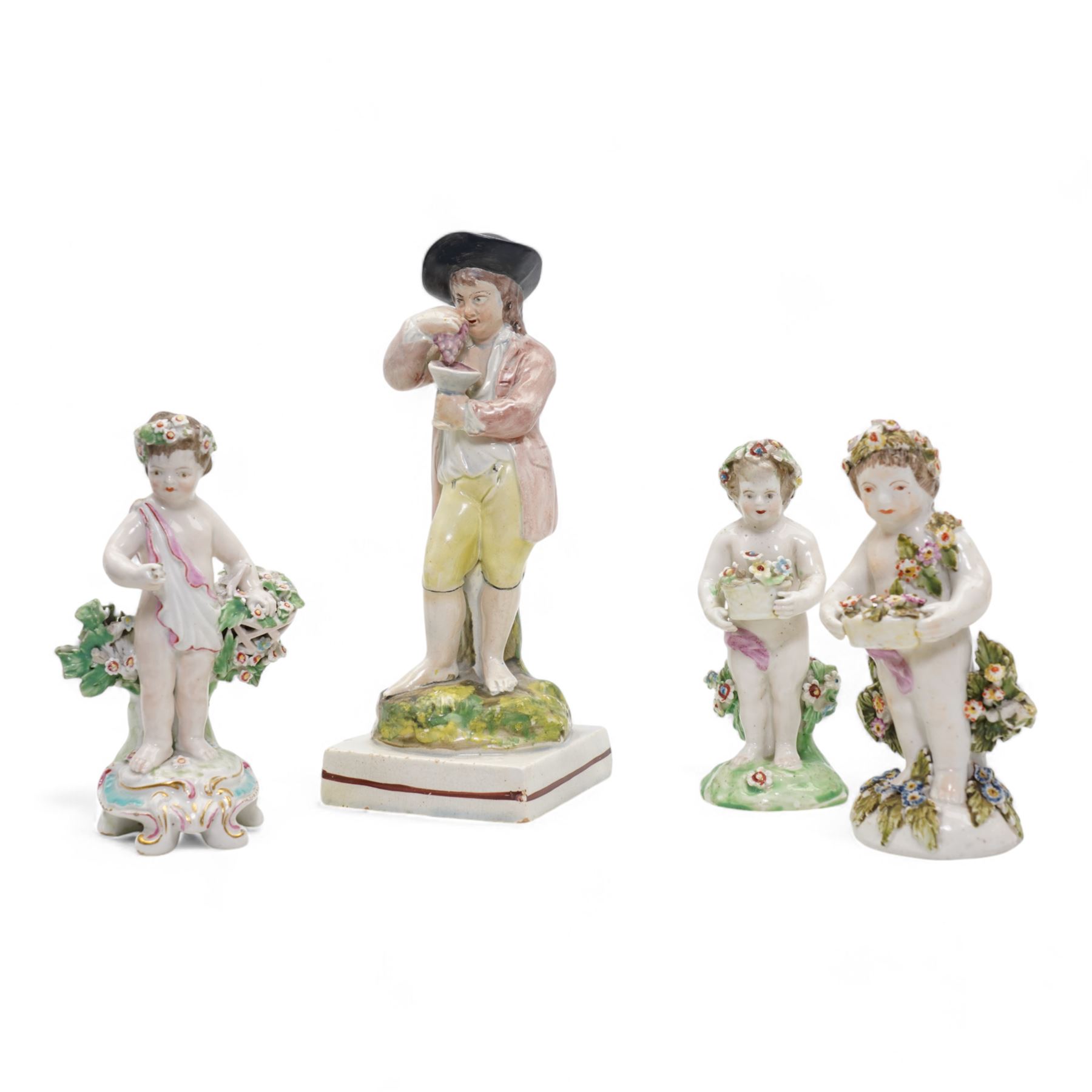Derby porcelain model of a cherub holding a basket of flowers and wearing a chaplet, H13cm, another Derby cherub holding a basket of flowers and another Derby style cherub, together with a 19th century Staffordshire Ralph Wood type pearlware figure emblematic of Autumn, holding grapes and a goblet (4)