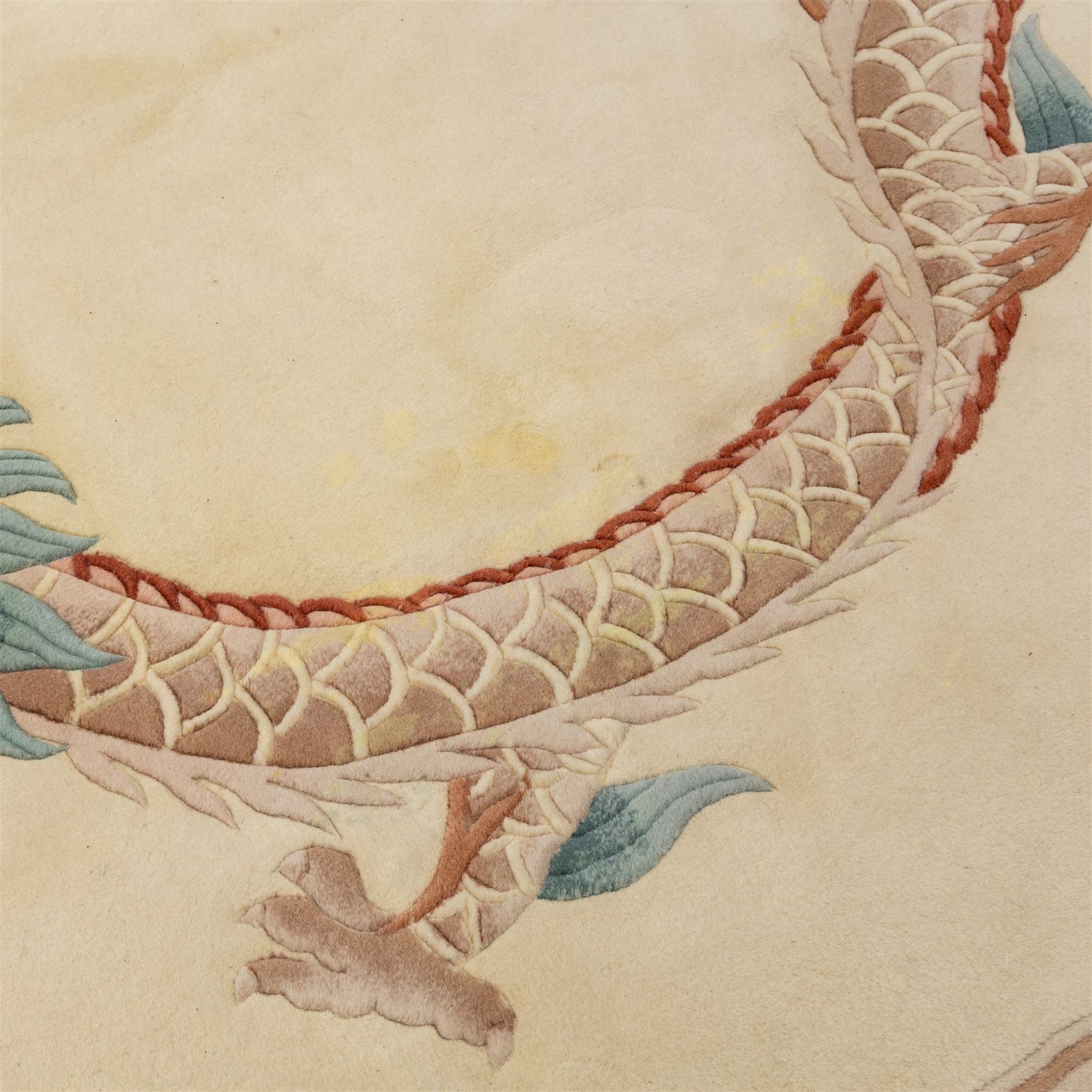 Late 20th century Chinese wool carpet, cream field with five stylized dragons arranged in a circular formation around a central flaming pearl motif, dragons depicted with elongated bodies and clawed feet amongst stylized cloud forms, enclosed within a narrow inner border and a wider outer border decorated with traditional Chinese motifs and symbols