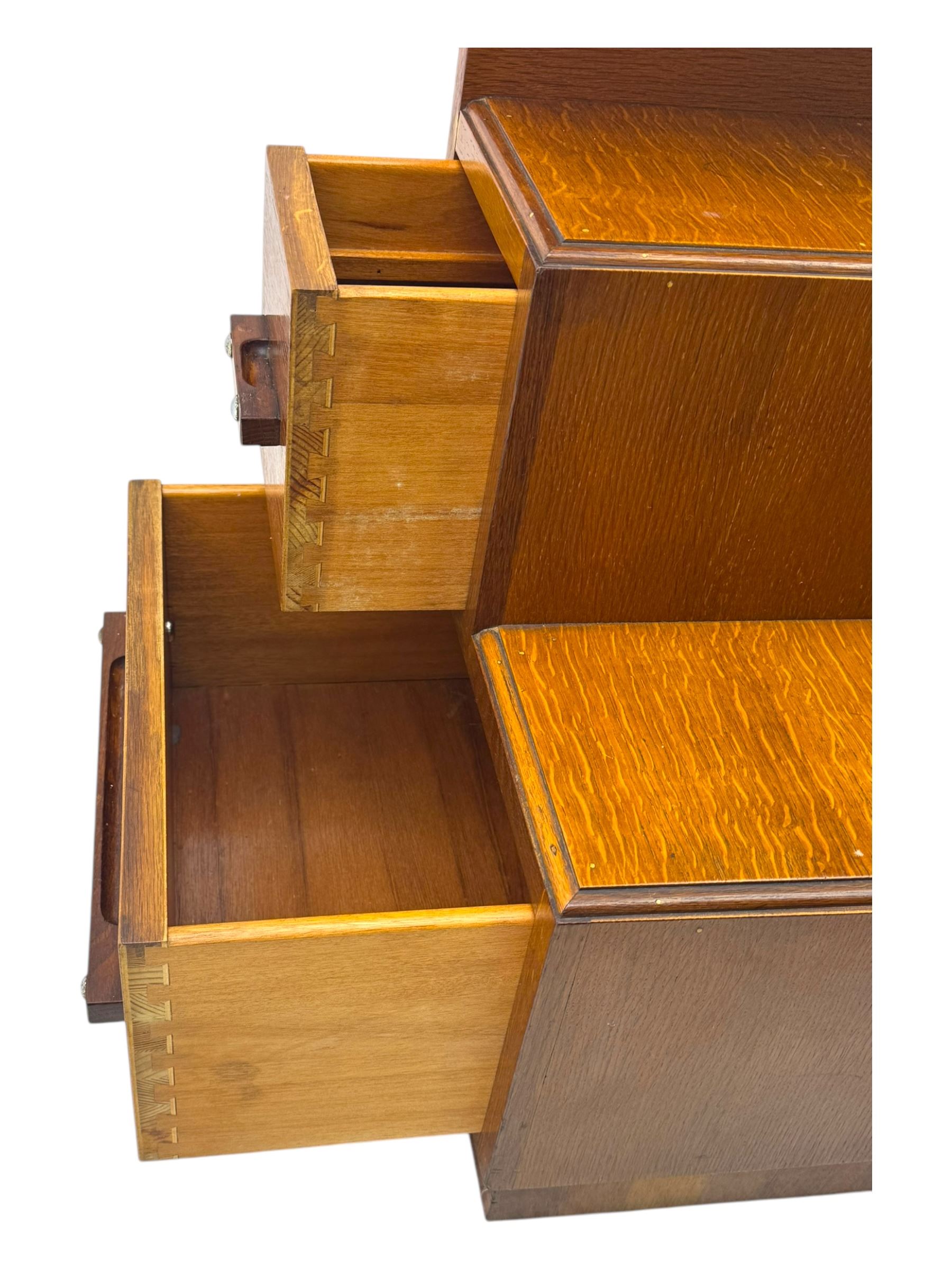 Early 20th century Art Deco walnut dressing table, featuring a large oval triptych mirror above a stepped base, fitted with four drawers and a central glass shelf, all raised on a plinth base