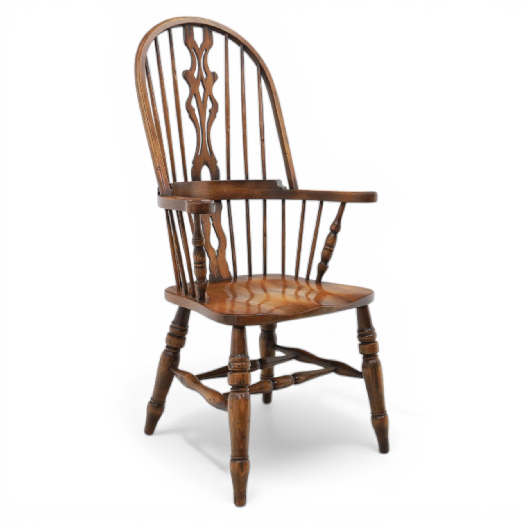 Late 20th century elm and beech high back Windsor armchair, the arched hoop back with pierced vase shaped splat between turned spindles, shaped arm rail on turned supports, saddle seat, raised on turned legs united by a crinoline stretcher