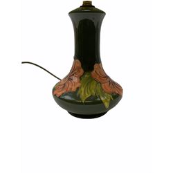 Moorcroft table lamp decorated in the hibiscus pattern on a green ground, with impressed mark beneath H25cm with impressed mark beneath together with a green lampshade.  