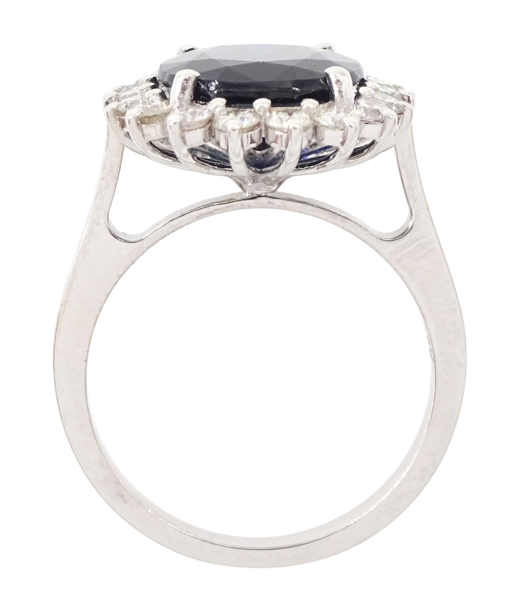 18ct white gold sapphire and diamond cluster ring, single oval cut sapphire of approx 4.30 carat, sounded by eighteen round brilliant cut diamonds, stamped, total diamond weight approx 0.75 carat