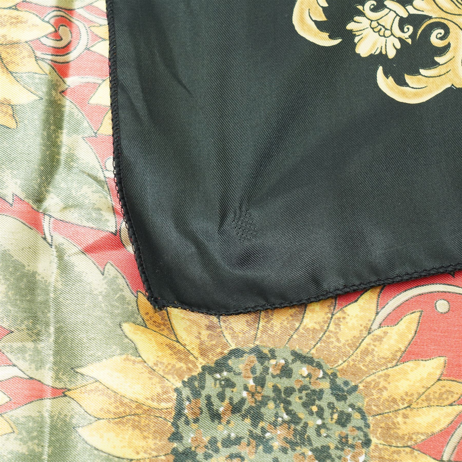 Hermès silk carré scarf, the black ground with central sunflower motif framed by ornate baroque panels and tassel borders in red, gold and yellow tones, signed Hermès Paris to the corner, hand-rolled edges, 90cm x 90cm