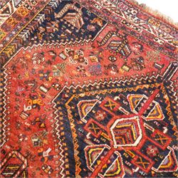 Persian Shiraz crimson ground rug, triple pole medallion surrounded by small stylised motifs depicting birds, animals and plants, within multiple band border each decorated with repeating patterns