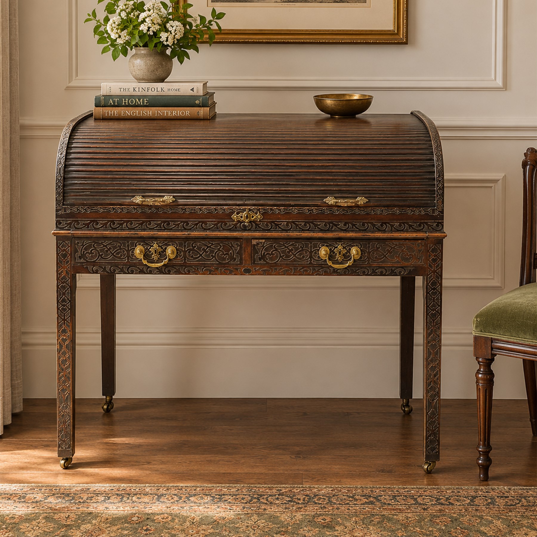 Late 18th century George III mahogany Chippendale design cylindrical roll-top desk carved profusely with geometric and foliate blind-fretwork throughout, the tambour-roll top opening to reveal pigeon holes over an inset red leather writing surface, fitted with two frieze drawers below, raised on square supports with inner chamfer terminating to brass castors, circa 1780s