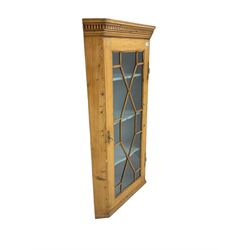 Early 19th century pine corner cabinet, projecting dentil cornice over astragal glazed door