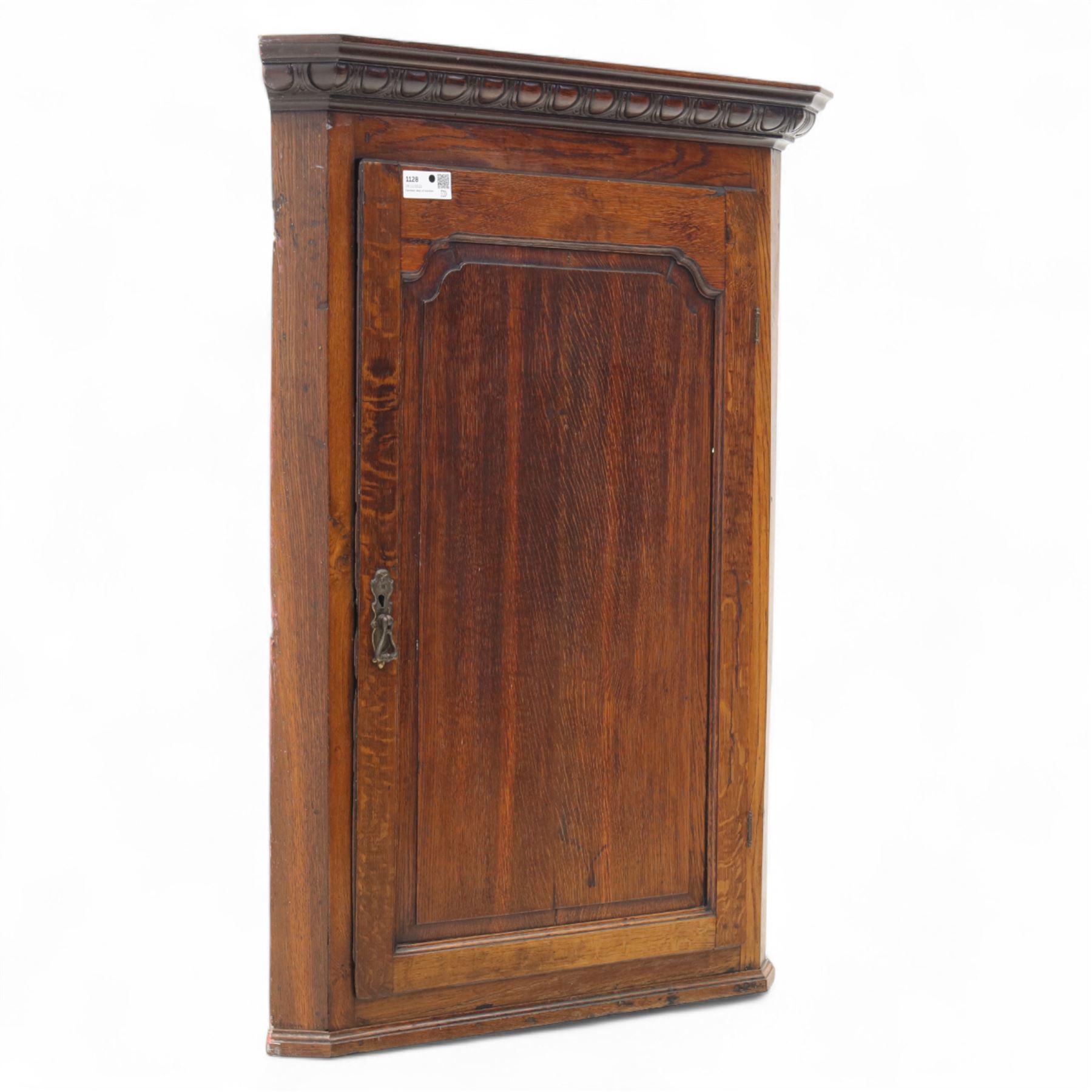 19th century oak wall hanging corner cupboard, moulded cornice above a panelled door enclosing shaped interior shelves, finished in green paint to the backboards
