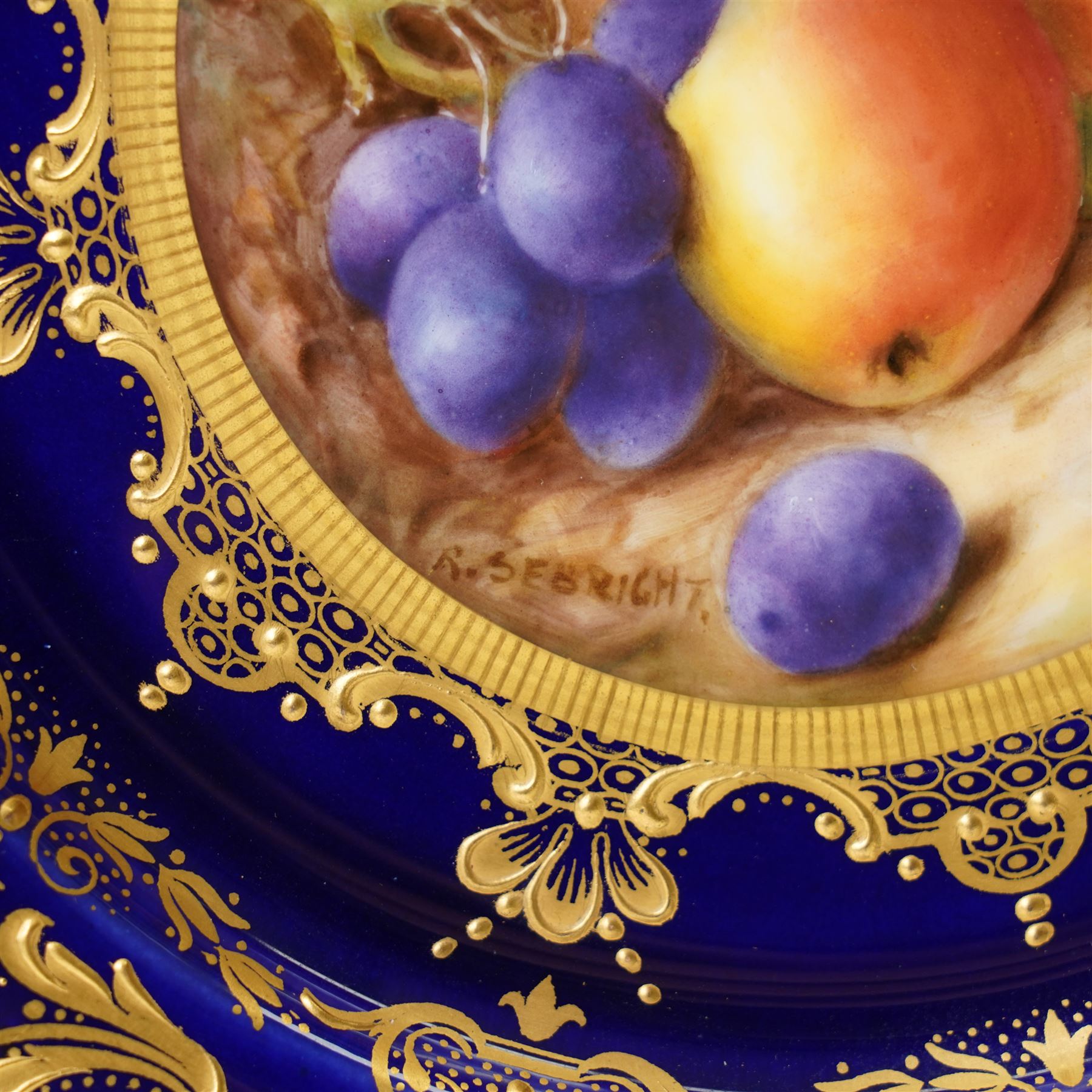 Royal Worcester Cabinet Plate, painted by Richard Sebright, the central panel decorated with fruit, within an elaborate gilt border on a cobalt ground, marked to base, D22cm 
