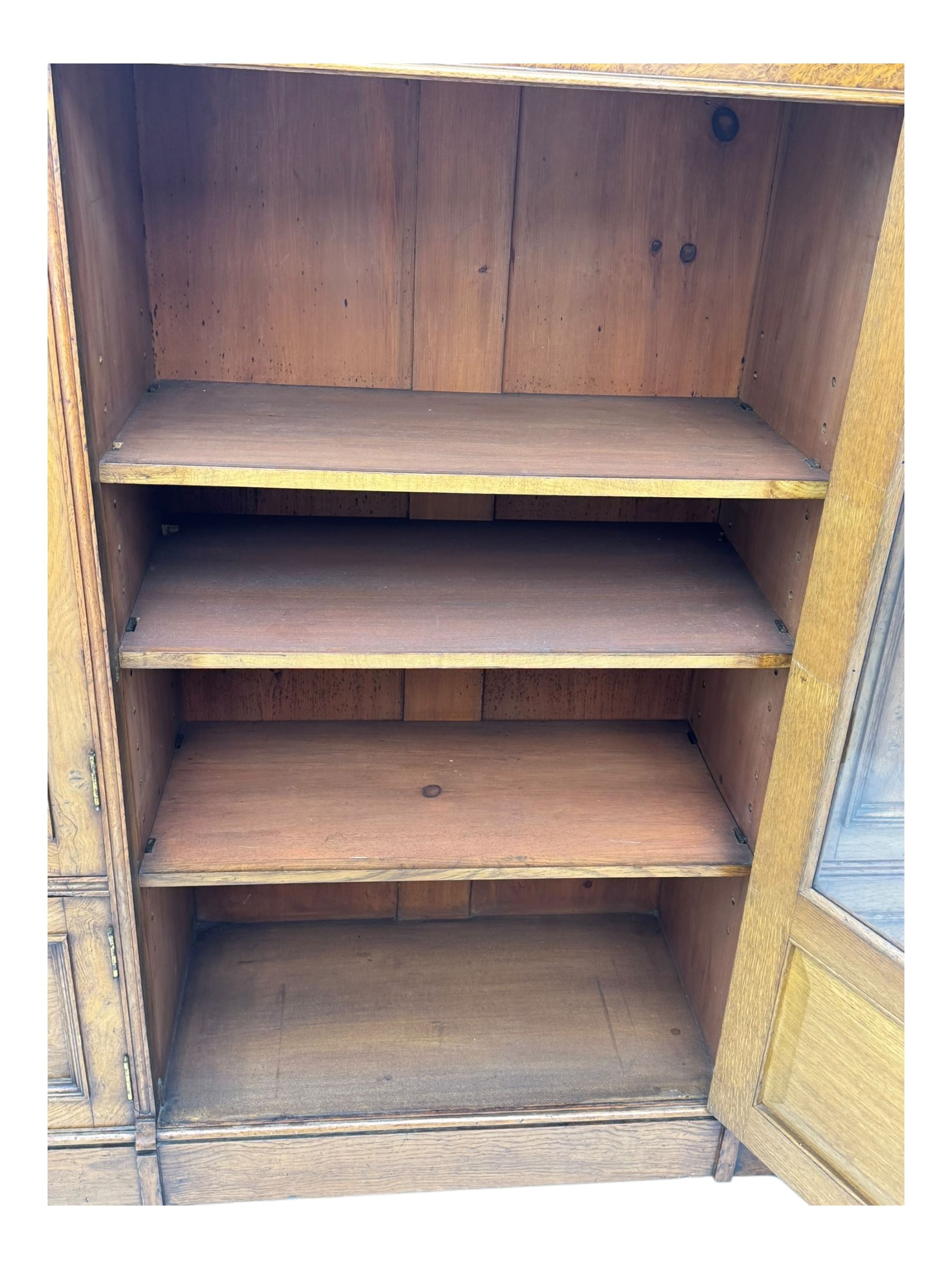 Late Victorian pollard oak bookcase or sideboard, the central glazed door opening to reveal adjustable shelves and interior makers label 