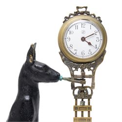  20th century-8-day Marsupial mystery clock with a cast brass patinated model of a standing Kangaroo on a wooden base, with a swinging compound pendulum resting on two steel pivots, white dial with Arabic numerals, minute track and steel spade hands, wound and set from the rear.