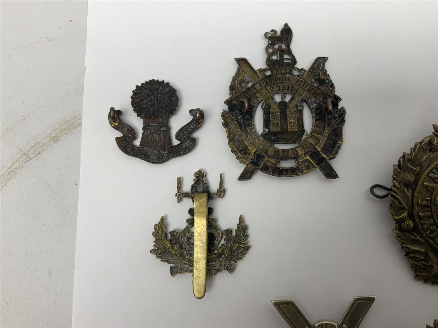 Fifteen Scottish Glengarry and other metal military badges including Argyll & Sutherland, Royal Glasgow Yeomanry, Cameronians, Lanarkshire Yeomanry, Kings Scottish Own Borderers, Highland Light Infantry, Border Regiment, Lowland Regiment, Lothians & Border Horse Yeomanry, Ayrshire Earl of Carricks Own Yeomanry etc