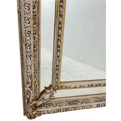 Large painted and gilt arched wall mirror, the frame decorated with scrolling leafy branches, central bevelled mirror mirror surrounded by plain panels, decorated with cartouche mounts 