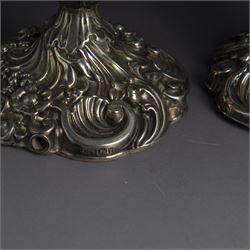 Pair of late Victorian silver candlesticks, each embossed wth floral, foliate and scrolling decoration, with removable sconces and upon a weighted embossed base, hallmarked Jenkins & Timm, Sheffiled 1891, H20cm