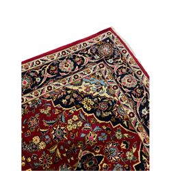 Persian red ground Kashan rug, decorated with flower and plant motifs with central medallion, repeating guarded border 