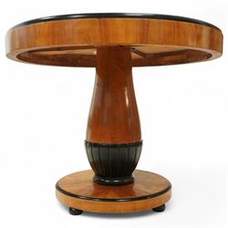 Mid-20th-century Biedermeier-style ebonized and satinwood pedestal table, quarter-veneered circular top with ebonized edge above a tapered baluster quarter-lobed column, raised on a circular plinth base, D87xH70cm, together with two matching upholstered spoon back chairs W45xD47xH87cm
