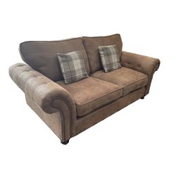 Two seat sofa upholstered in studded and buttoned suede fabric, scrolling arms, turned supports