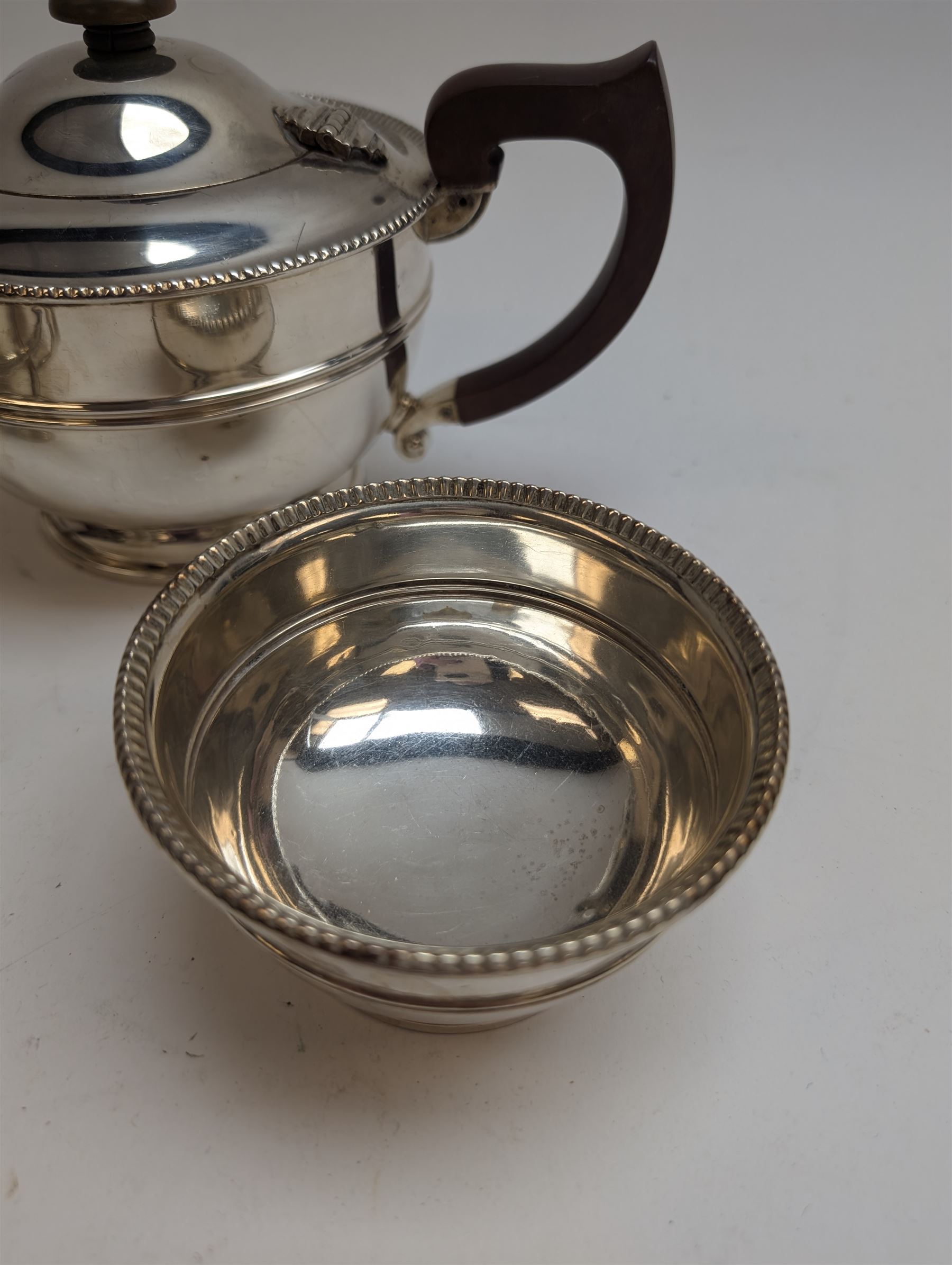1930s silver three piece tea service, comprising teapot, milk jug and sugar bowl, each of circular form with oblique gadrooned rim, the teapot with Bakelite handle and finial, hallmarked Mappin & Webb Ltd, Birmingham 1931, teapot H14.5cm