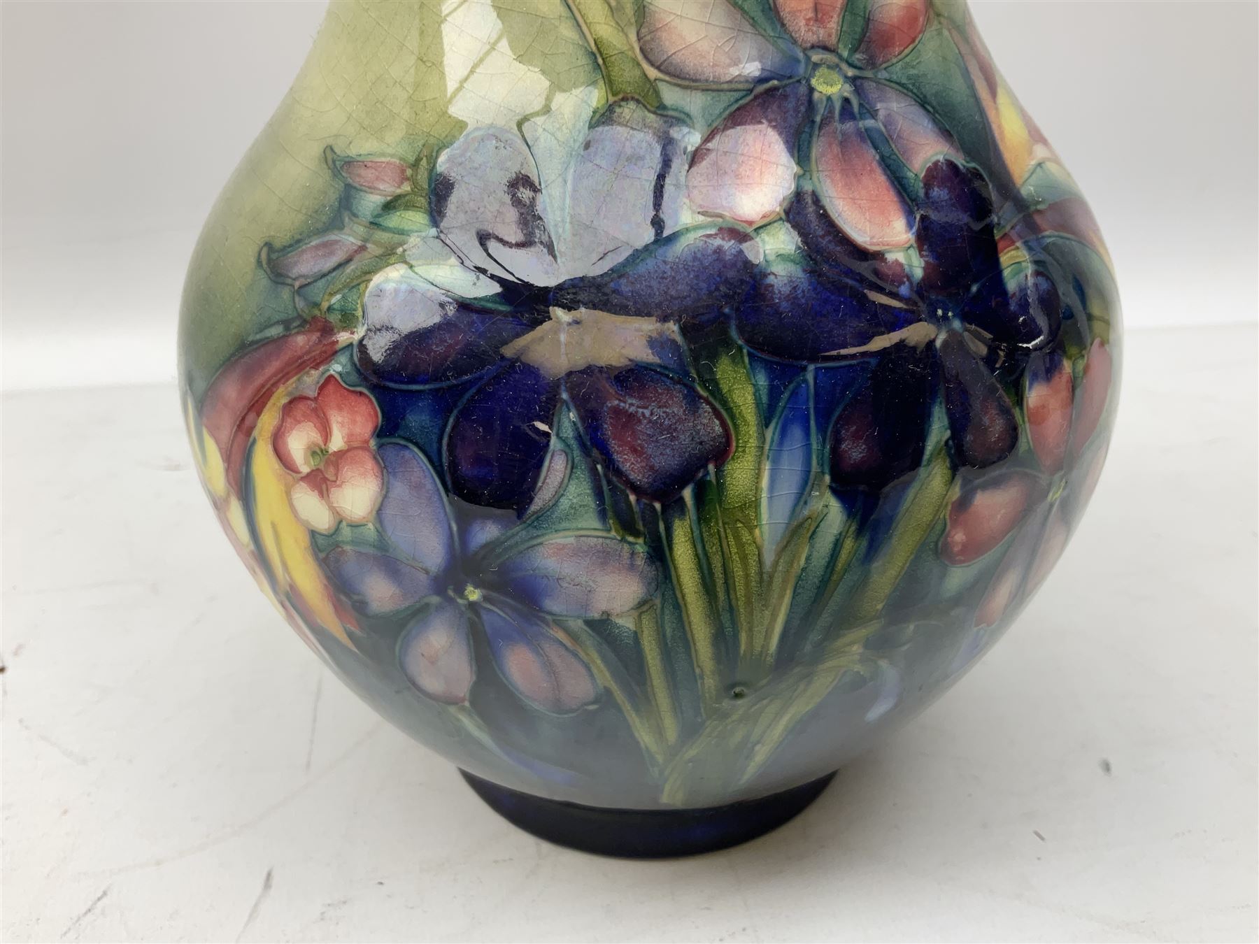 Moorcroft vase of baluster form decorated in the Spring Flowers pattern upon a merging green and blue ground, with impressed and painted marks beneath, H22.5cm