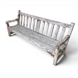 Teak garden bench with slatted back and seat on square supports in weathered which finish 