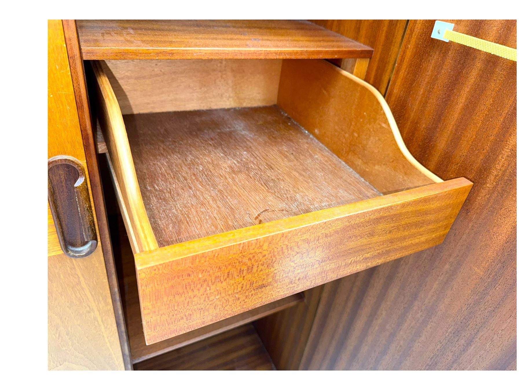 William Lawrence - mid-20th century teak double wardrobe, upper storage section over twin doors featuring recessed handles and contrasting horizontal panel, enclosing hanging rail compartment, towel rail, mirror, shelves and drawer, on plinth base with concealed castors