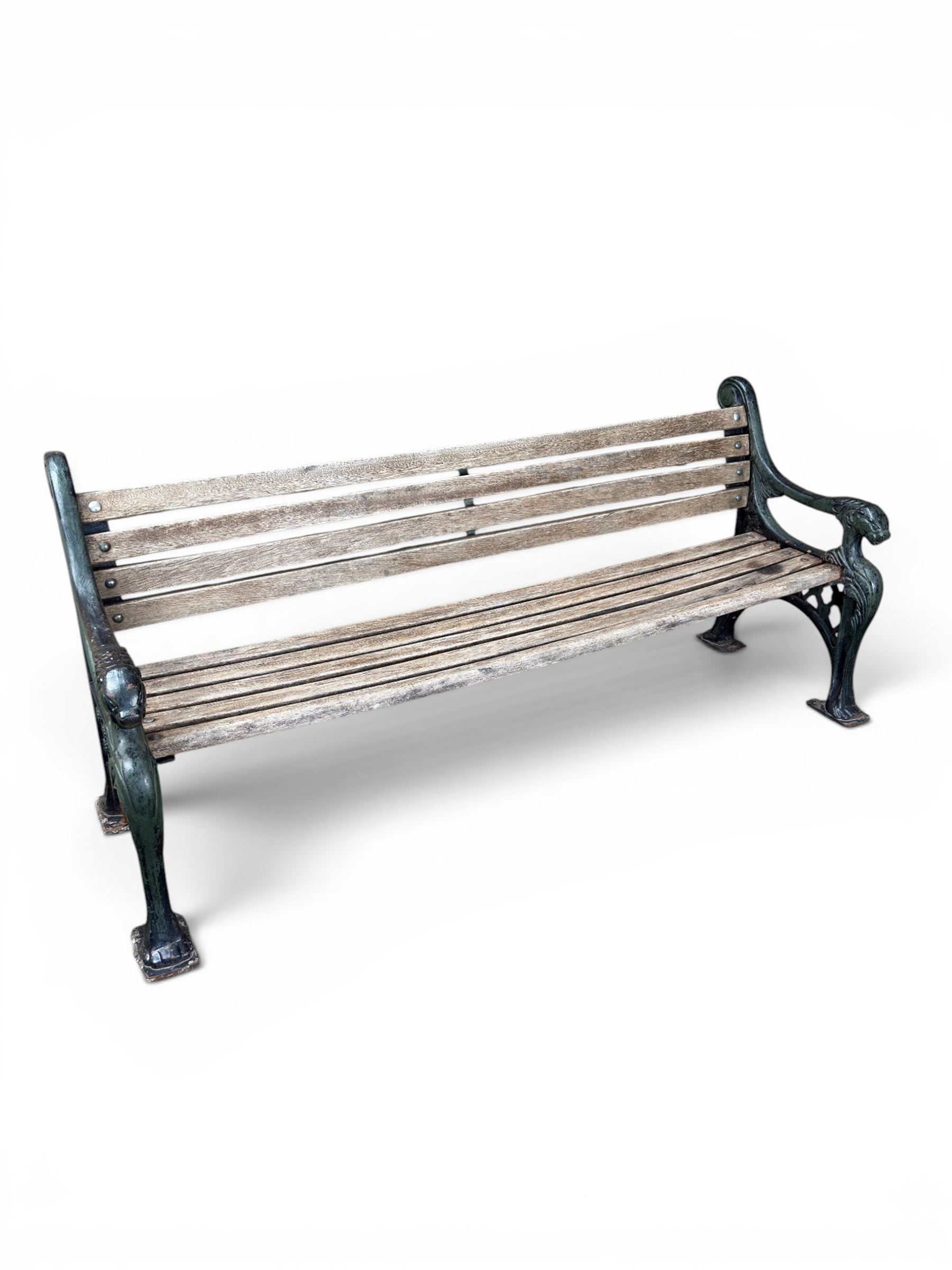 Neoclassical design cast iron and oak slatted garden bench, the twin end supports in the form of a Sphinx with acanthus carved knees and large paw feet, the pierced lattice bracket with Yorkshire rose motifs