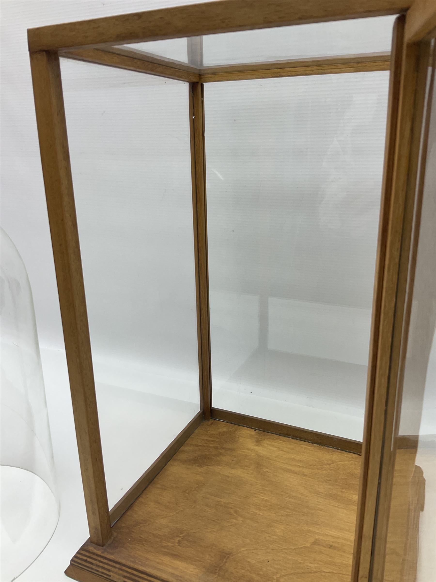 Tabletop glass display cabinet, with hinged door, together with two glass domes