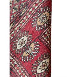 Tekke Bokhara red ground rug, decorated with two rows on Gul motifs, geometric design borders decorated with stylised floral motifs 