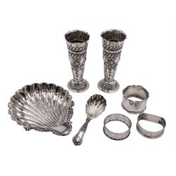 Group of silver, comprising Edwardian silver shell butter dish, upon three ball feet, hallmarked Joseph Rodgers & Sons, Sheffield 1904, together with an Edwardian silver Kings pattern caddy spoon, with fluted shell bowl, hallmarked London 1904, maker's mark worn and indistinct, a pair of late Victorian silver specimen vases, with shaped rims and chased and repousse decorated with flower heads, oblique gadrooned borders and fish scales, each upon circular spreading foot, hallmarked Josiah Williams & Co, London 1899, H11cm etc