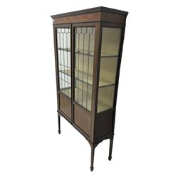 Edwardian mahogany display cabinet, the frieze inlaid with bell flower garlands, enclosed by panelled and glazed doors, lead glazed panels with bullseye roundels, on square tapering supports with spade feet