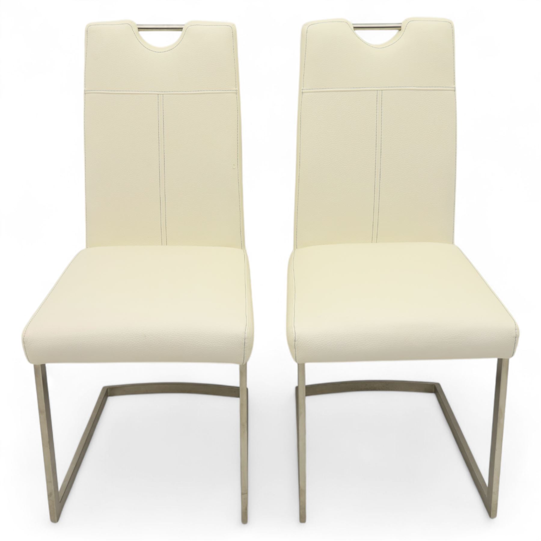 Set of seven contemporary style dining chairs, each with a high padded back and seat upholstered in faux leather on brushed steel sled bases  