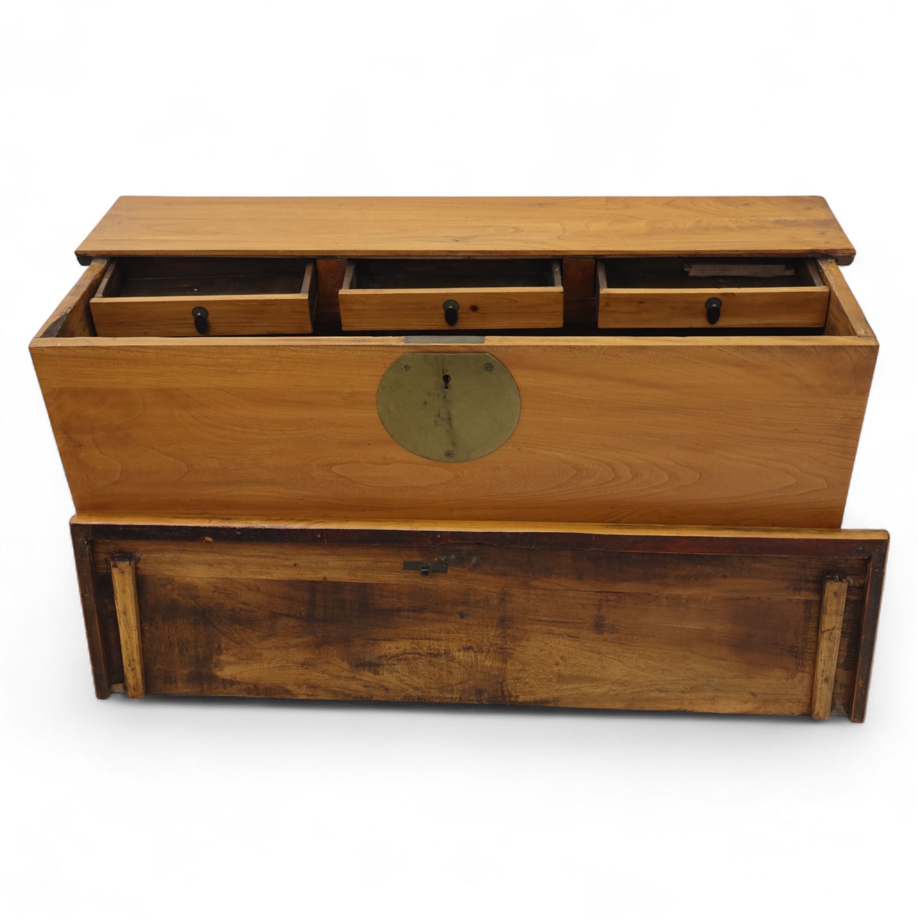 Burmese hardwood and brass inlaid marriage chest, the hinged top enclosing a fitted interior with small drawers, the front decorated with a circular brass medallion, raised on a plinth base