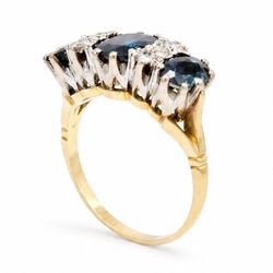 18ct gold sapphire and diamond ring, three graduating oval cut sapphires, the principal stone with two round brilliant cut diamonds set either side, London 1975, total sapphire weight approx 2.70 carat