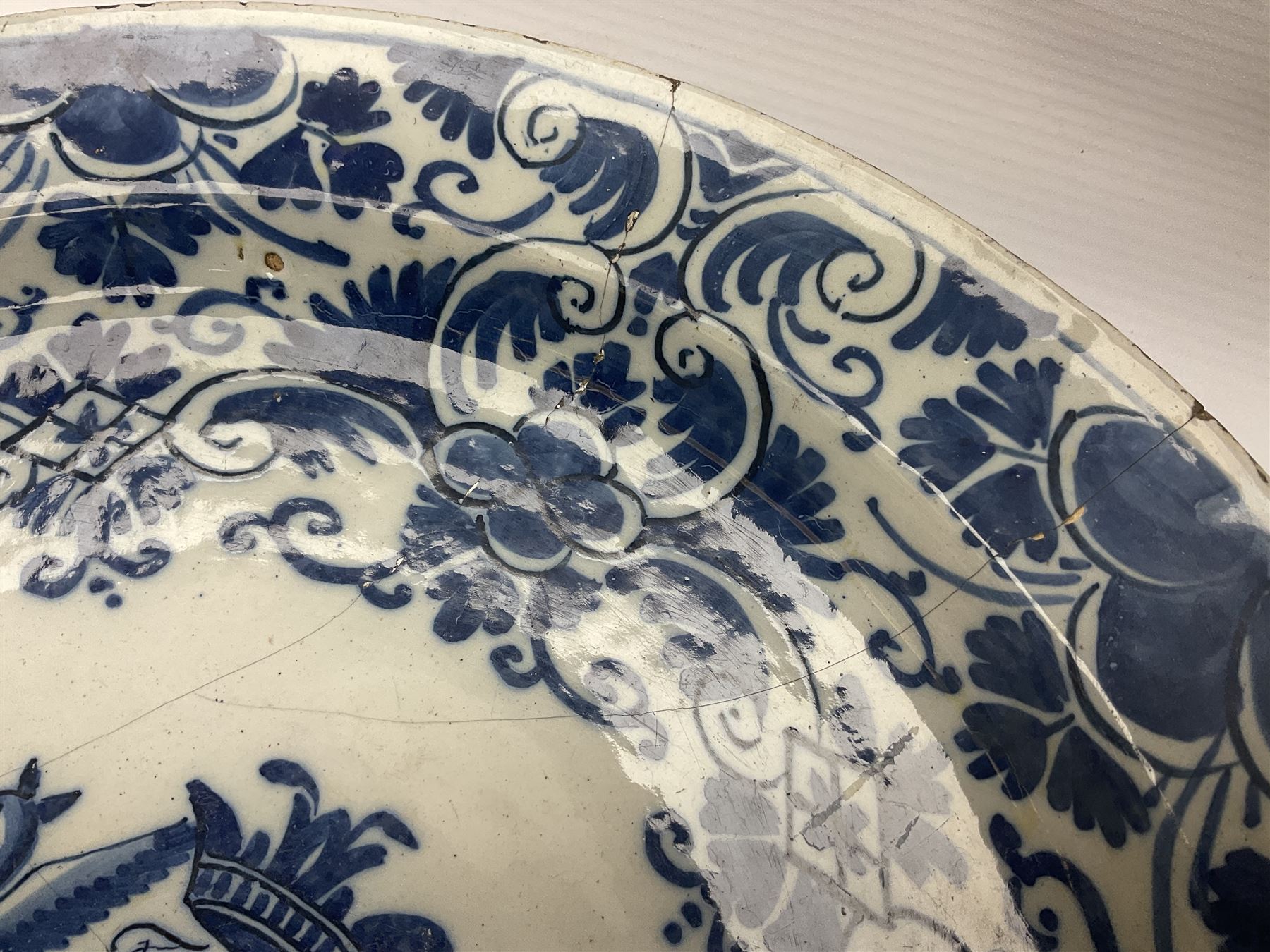 Early 18th century Delft marriage plate, of circular form with dished centre, the centre inscribed and dated 'Thomas and Elizabeth Kockerill Bridlington Key 1715' within a crowned C scroll cartouche, flanked by demi-griffins, above a putto head and tassels, within a wide foliate border, D34cm
