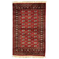Persian Bokhara crimson ground rug, the field decorated with repeating Gul motifs and lozenges, the multi-band border with stylised plant motifs with black outlines