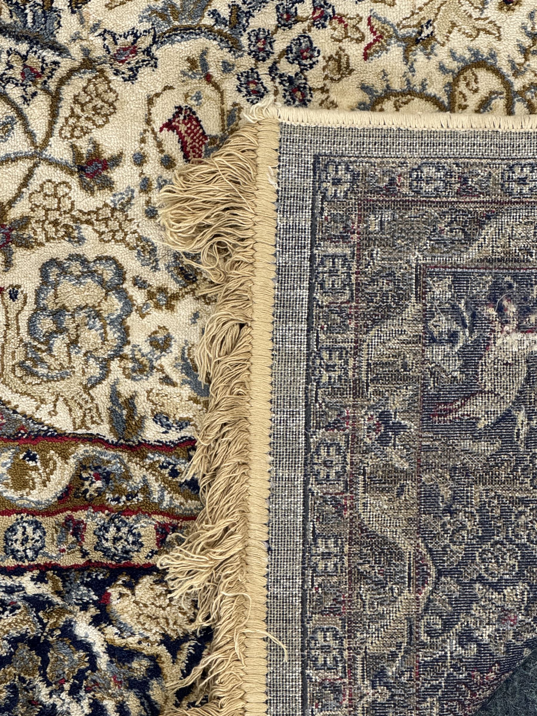 Persian Kerman ivory ground rug, the field adorned with naturalistic depictions of birds, animals and floral designs, framed by a multi-band border in blue and red tones