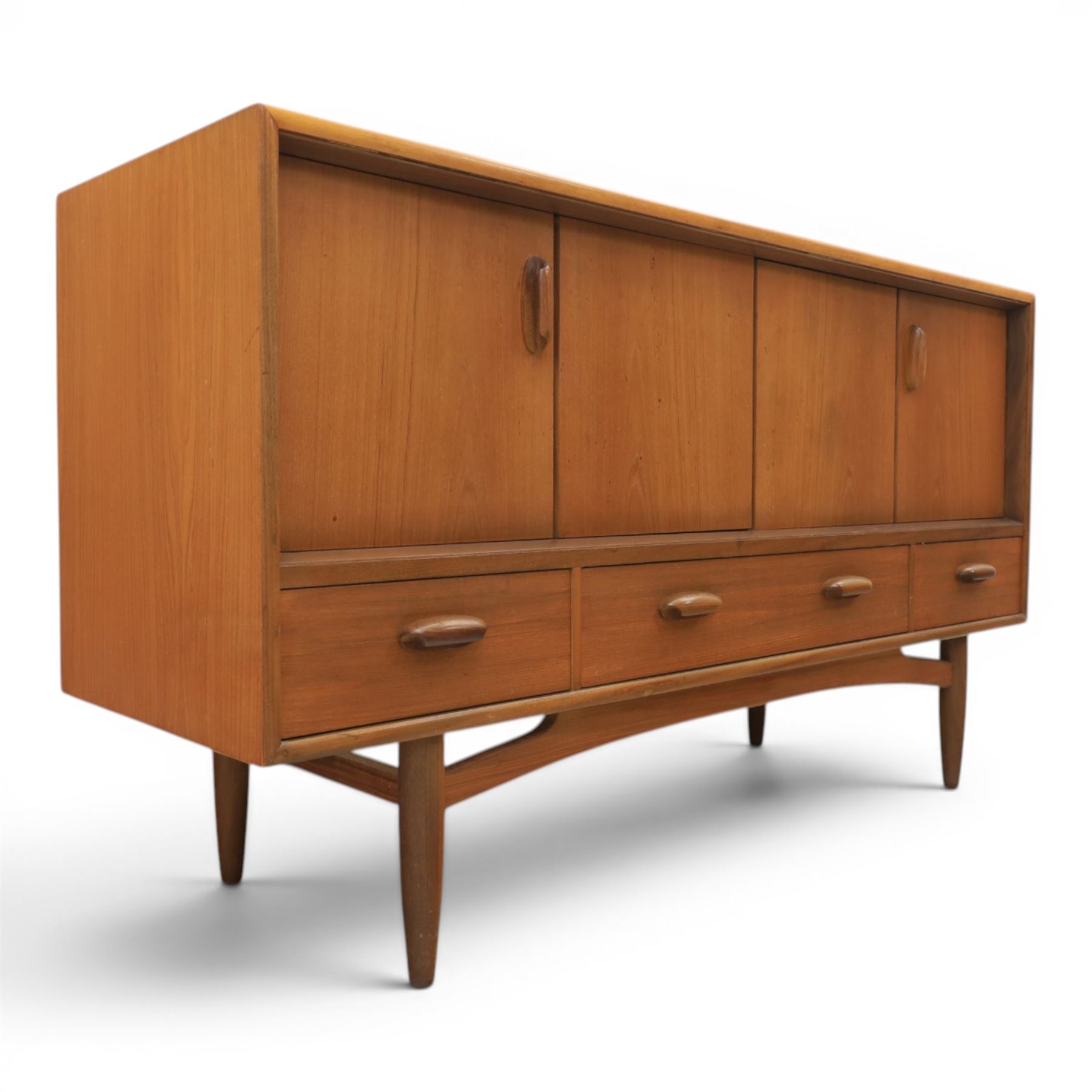 G-Plan - 'Brasilia' teak sideboard, with rectangular top above two concertina doors, above four drawers raised on cylindrical supports