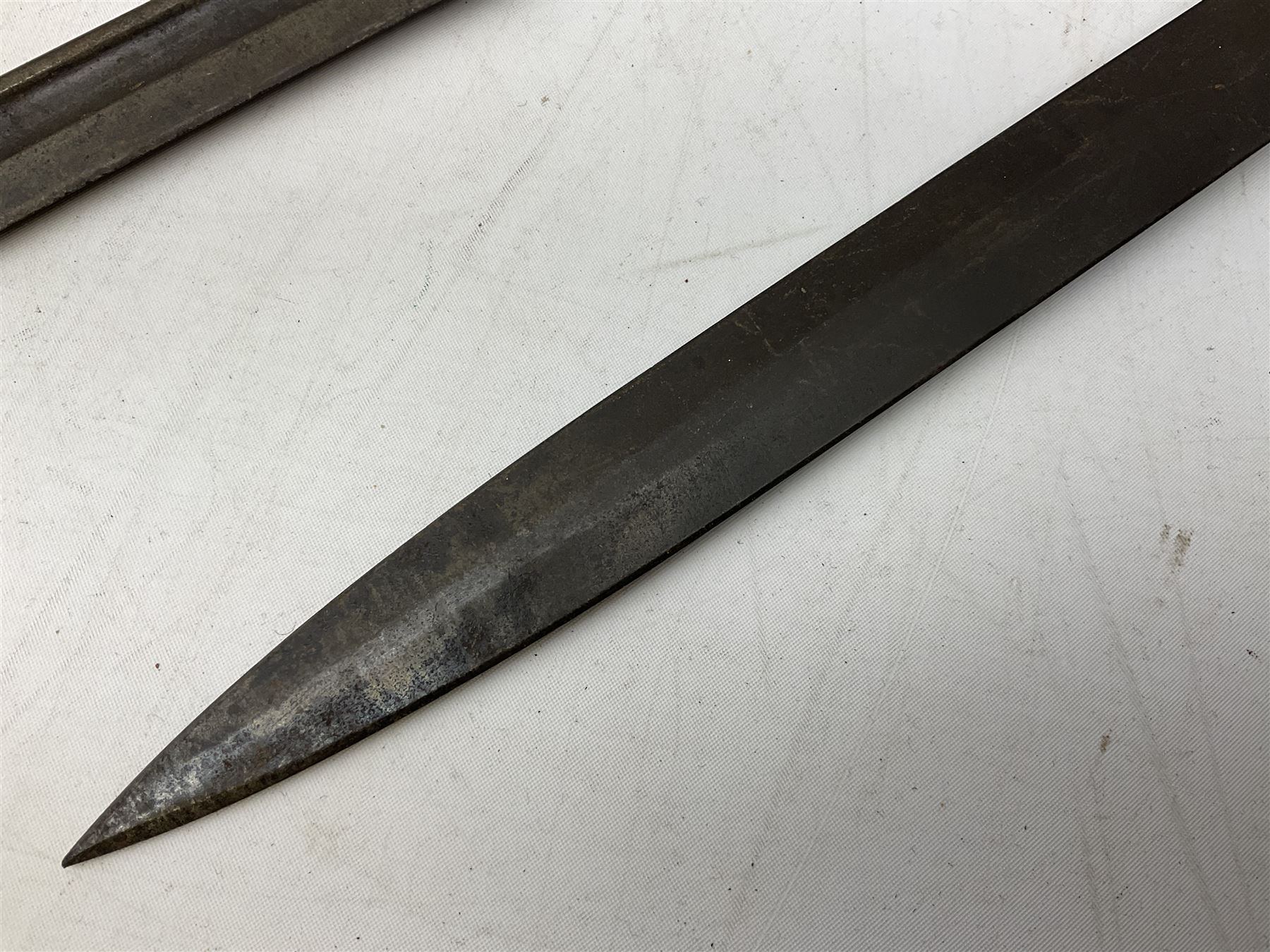 British Pattern 1907 bayonet with 43.5cm fullered steel blade; in leather scabbard with webbing frog L58cm overall; another Pattern 1907 bayonet lacking scabbard; and British Pattern 1888 Mk.I bayonet by Wilkinson London (no scabbard) (3)