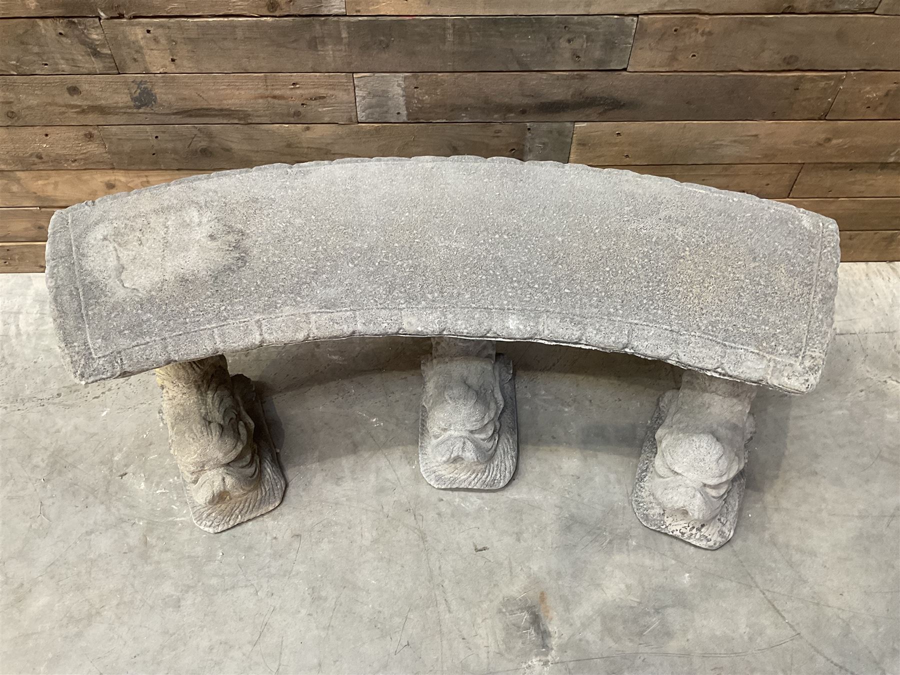 Cast stone four piece curved Dolphin bench, set with three dolphin pillars, curved rectangular slab top with detailed border