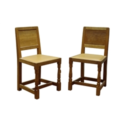  Pair 'Mouseman' oak dining chairs, panelled adzed back, seat upholstered in studded soft leather, by Robert Thompson of Kilburn  