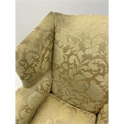 Duresta - pair beech framed wingback armchairs, upholstered in pale gold fabric decorated with raised floral pattern, feather loose cushions, square tapering front supports with brass castors, splayed rear supports 