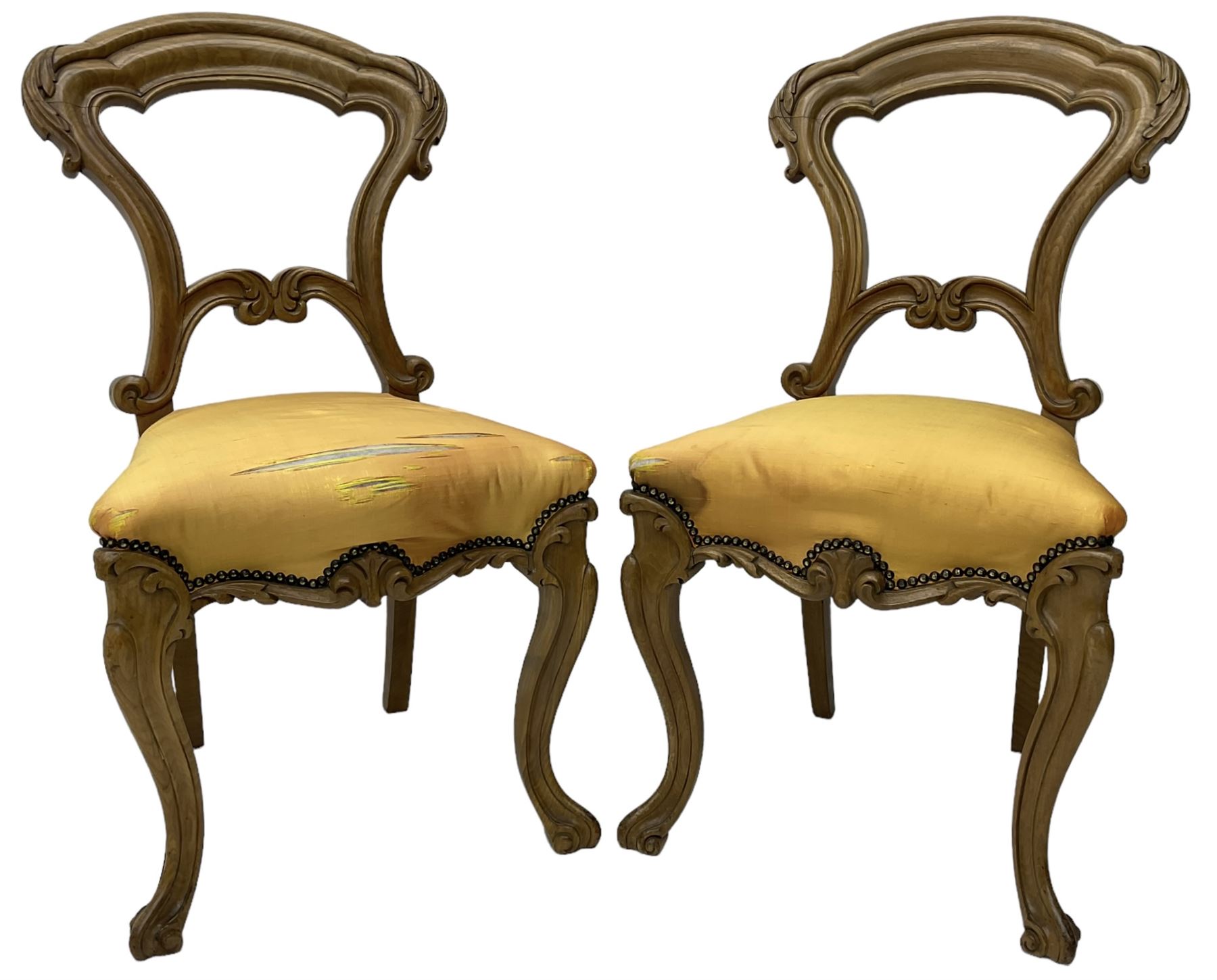 Pair of Victorian walnut side chairs, shaped cresting rail carved with acanthus leaves, overstuffed upholstered seats with stud band, on cabriole supports with scroll carved terminals