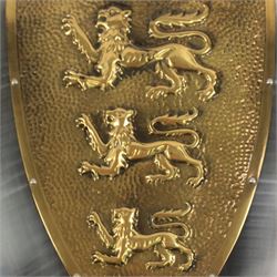 Five wall hangings, modelled as shields, decorated to the centre in relief with three lions 