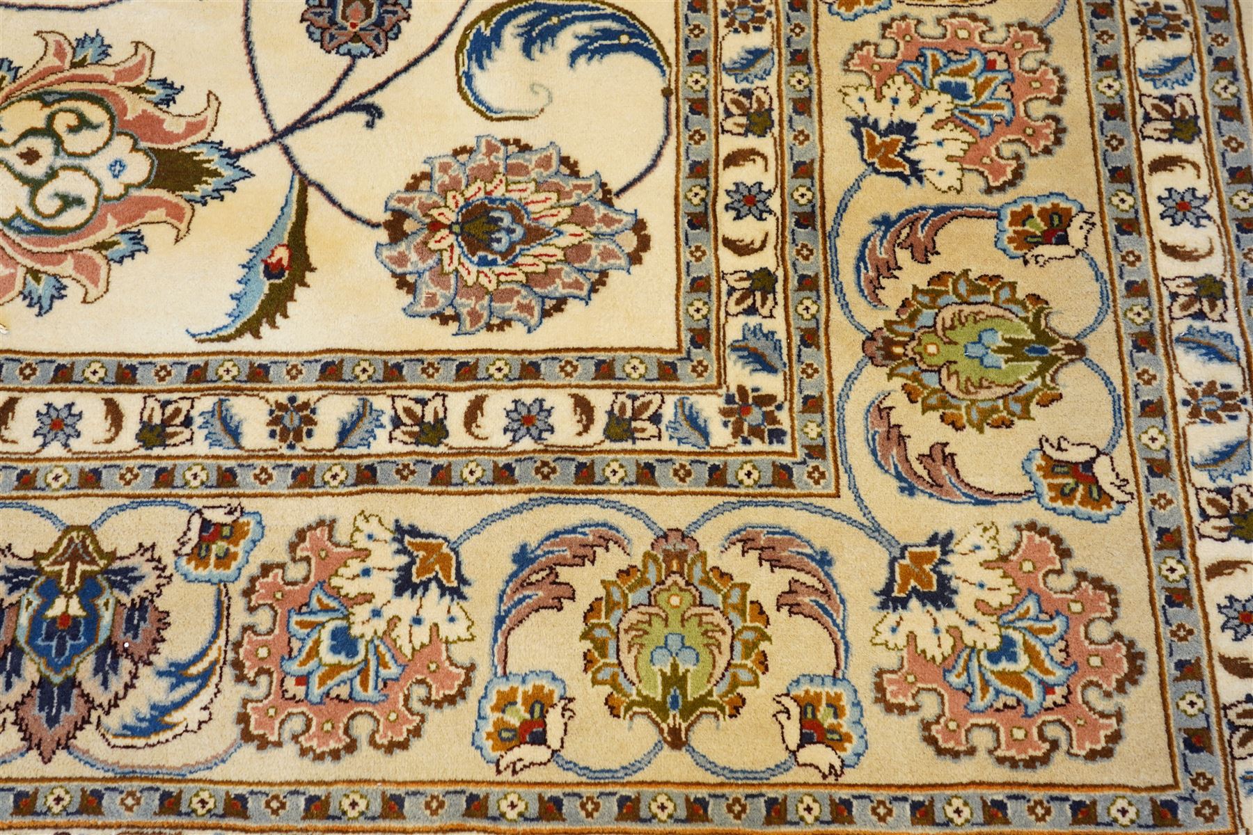 North East Persian Mashad hand-knotted carpet, ivory field decorated with an all-over scrolling floral vine design incorporating stylized palmettes, deer, rosettes and floral sprays enclosed by a conforming floral vine border between multiple guard stripes, cotton fringe ends