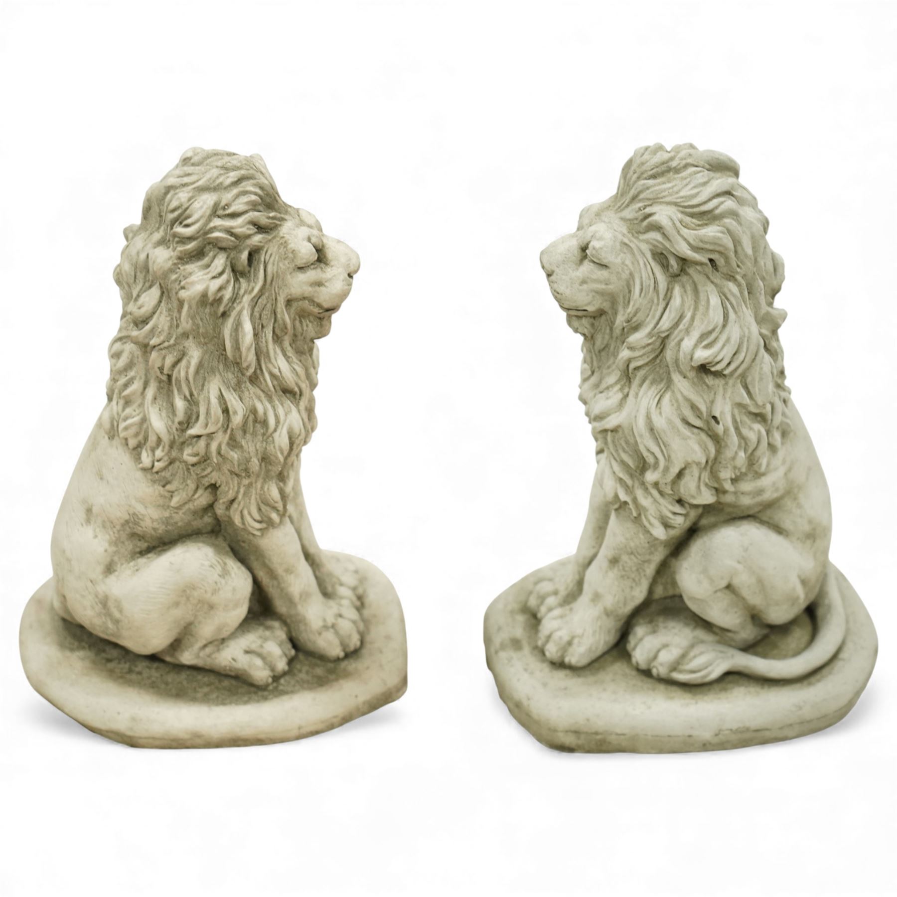 Pair of contemporary cast stone lions, seated pose on shaped plinths, with textured manes and aged surface finish