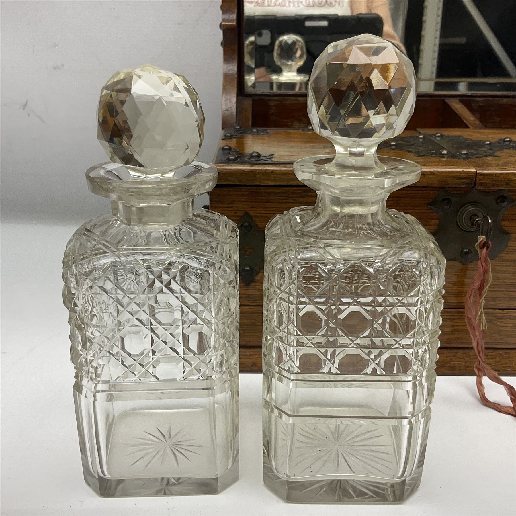 Victorian oak tantalus, mirrored high-back with recess for housing the decanters, behind a hinged box, with cribbage board to the concealed drawer below, marked Barman, London, H33cm, L37cm