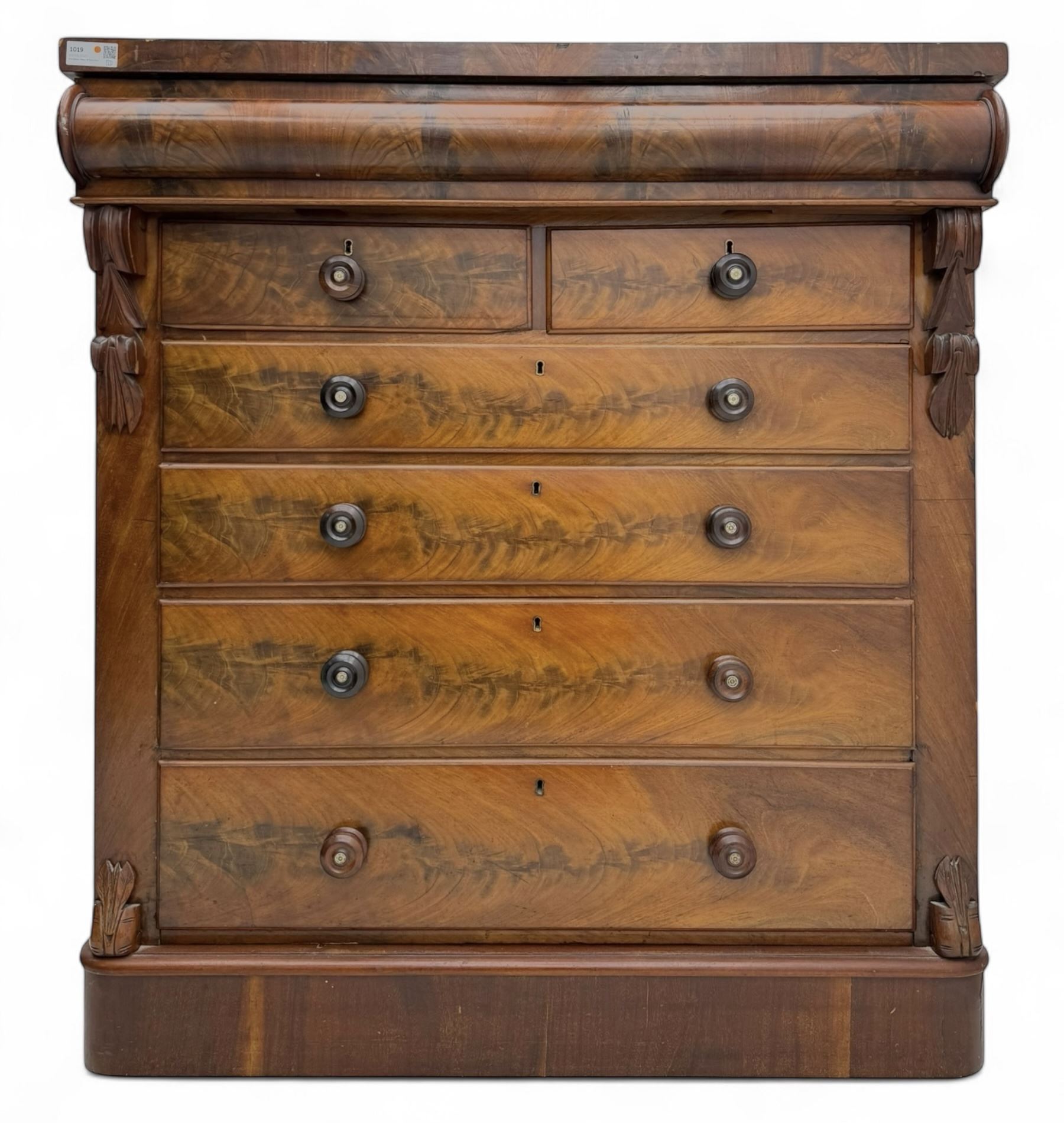 19th century flame mahogany Scotch chest, frieze long drawer above two short and four long graduating drawers, with turned knobs scrolled carved side bracket 