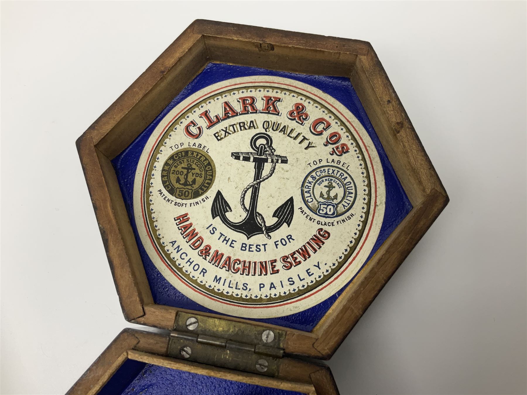 Mauchline ware black lacquered octagonal bobbin box, the hinged cover with forget-me-not floral decoration and sentimental verse, opening to reveal six bobbin holders and retail label for Clark & Co, together with a Mauchline ware sewing box, with floral decoration throughout and verse to hinged cover, a similar black lacquered needle holder and a Mauchline Tartan ware needle holder, largest diameter D11.5cm